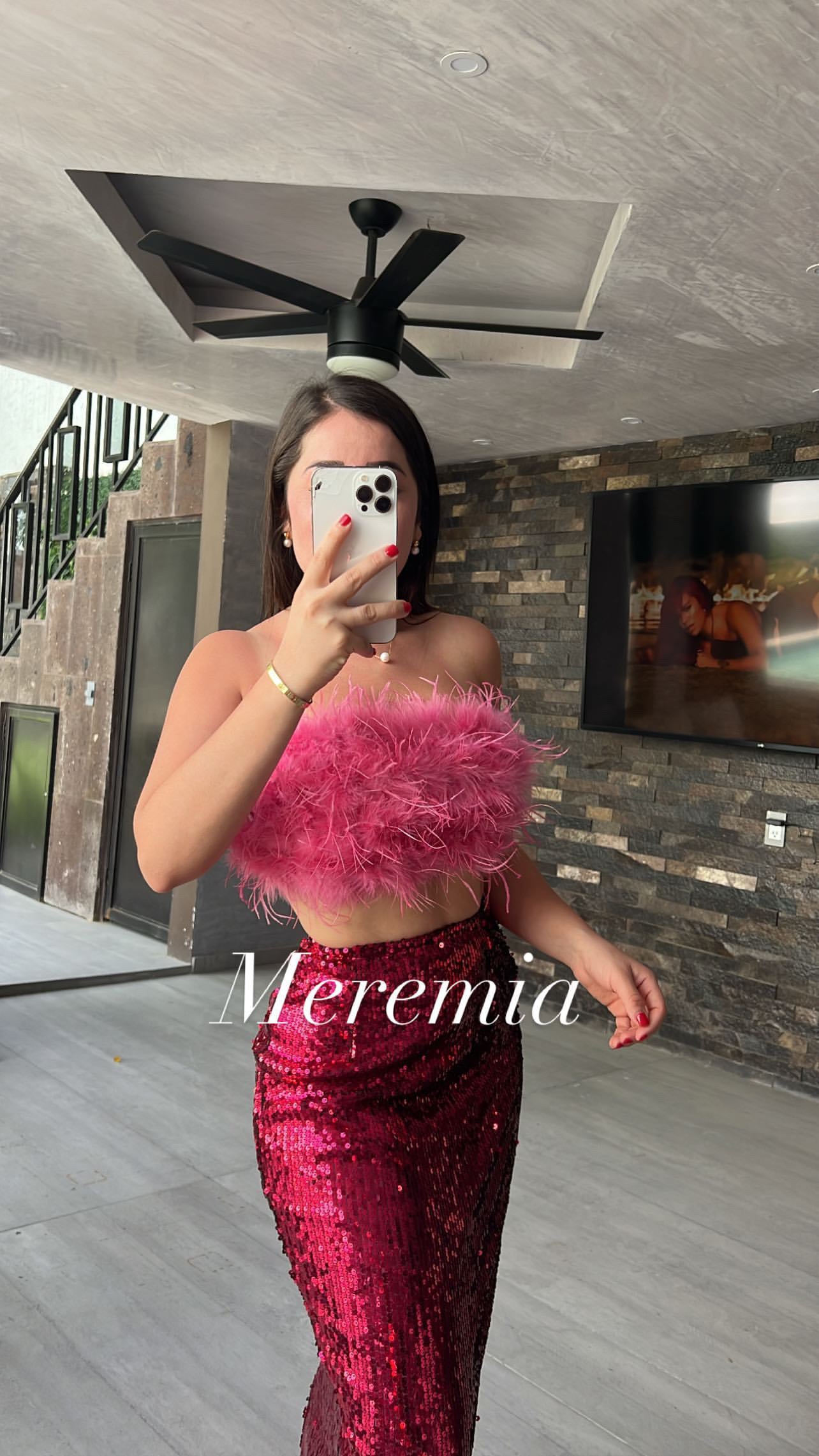 Conjunto rosa de top plumas y falda brillosa